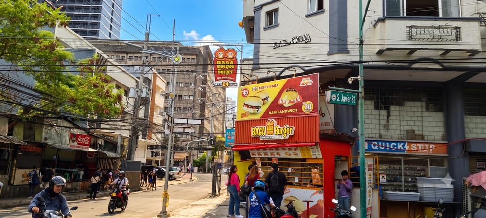 マニラの街角。地元のファストフード店やコンビニ、バイクが行き交う通りの風景